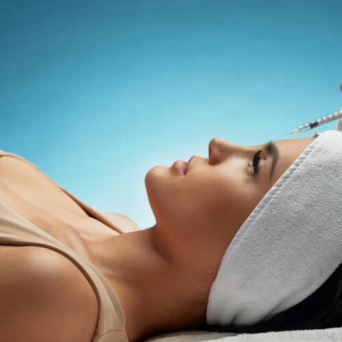 Evolve Health's Aesthetics and Botox professionally applying BOTOX and Jeuveau with a small needle to a woman's forehead. The woman is on her back staring at the ceiling. She is calm and showing no discomfort. This is because of the professionalism of Evolve Health's staff, which significantly minimizes the pain and swelling.