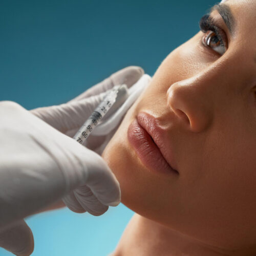 Evolve Health's Aesthetics and Botox professionally applying BOTOX with a small needle to a womans cheeks. The woman shows no pain or discomfort, highlighting the professionalism of Evolve Health's staff minimizing the pain and swelling.