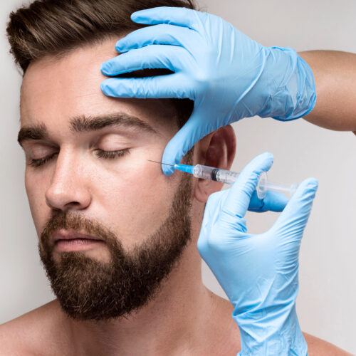 Evolve Health's Aesthetics and Botox professionally applying BOTOX and Jeuveau with a small needle to a mans face, near his eyes. The mans eyes are closed showing no pain, which reflects the professionalism of Evolve Health's staff minimizing the pain and swelling.