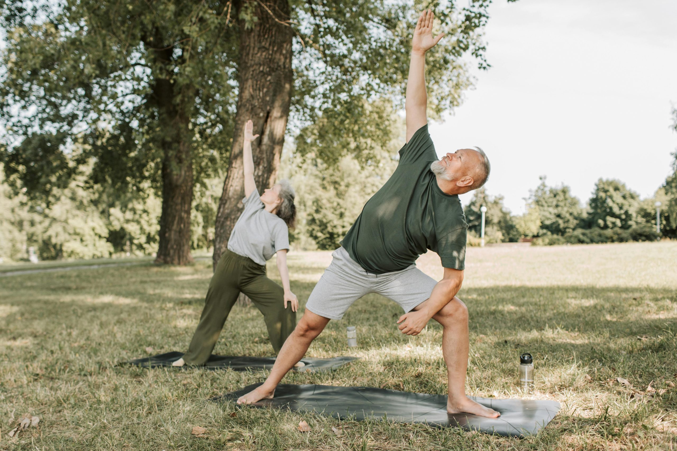 A man and a women doing yoga in a field